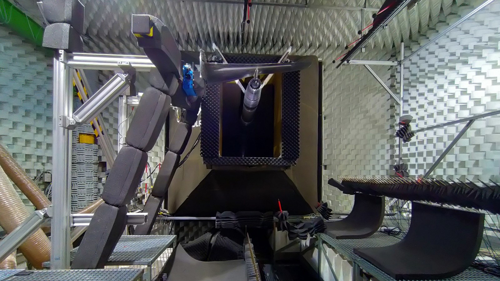 Rear view of the nozzle of the Braunscweig acoustic wind tunnel. The two microphone arrays are located below the Airbus wing and the Safran engine nozzle, and individual microphones are installed above the model. DLR/Airbus/Safran photo.