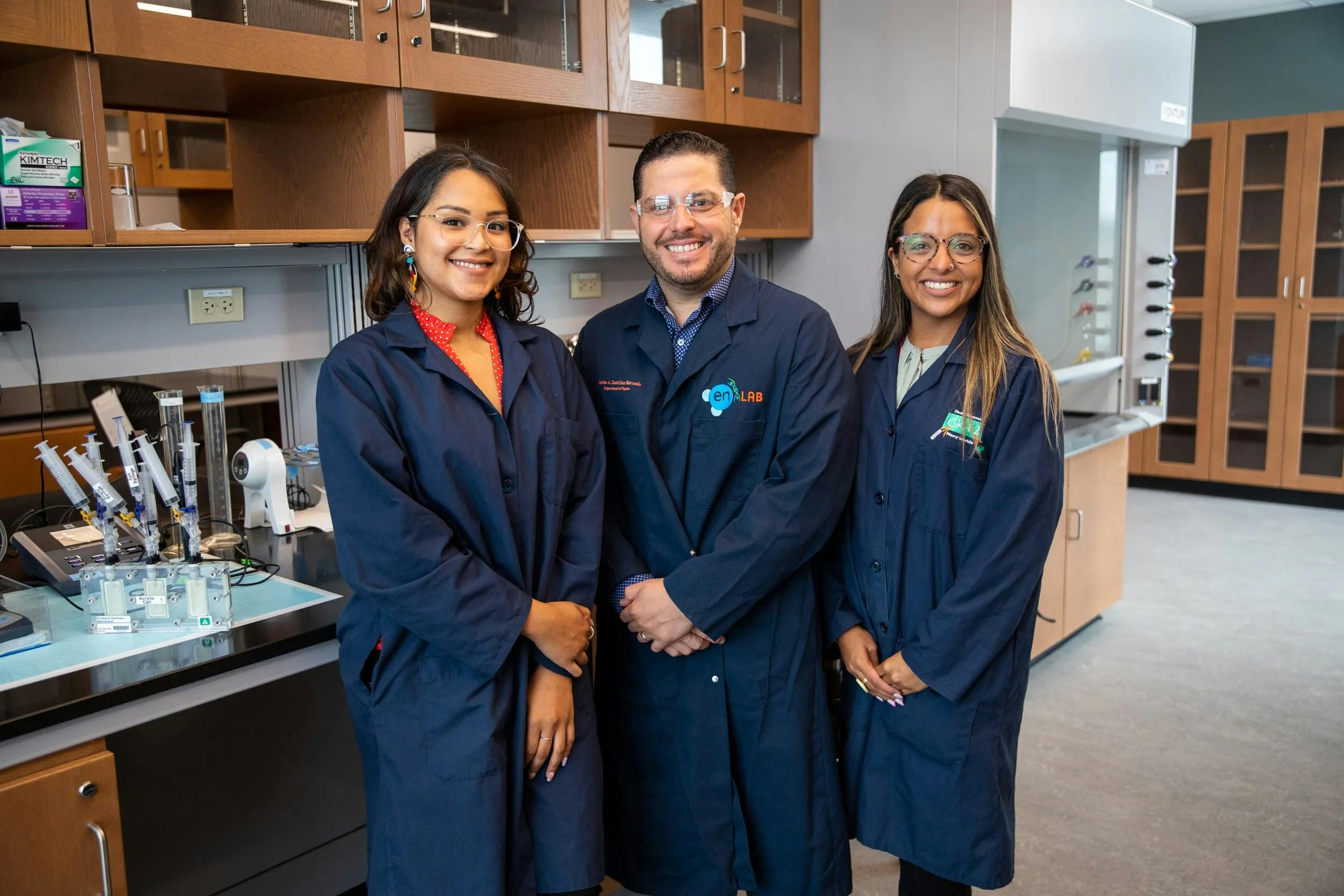 A photo of a team of researchers from the University of Puerto Rico-R&iacute;o Piedras while working to discover a more efficient water recycling system for use on space missions. The team is comprised of doctoral students Liz Santiago-Martoral, on the left, and Alondra Rodriguez-Rolon, and their mentor Professor Eduardo Nicolau. One of their experiments can be seen on the countertop to the left of the group. NASA photo.