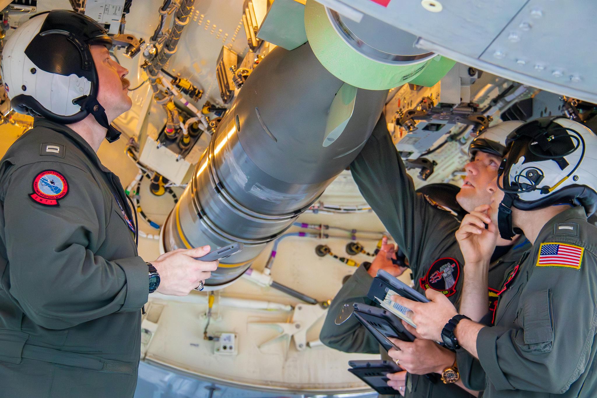 Navy flight officers conduct checklist items to ensure the MK 54 Warshot Torpedo is secured and supported inside the weapons bay of a P-8A Poseidon at Whidbey Island Naval Air Station, Wash.