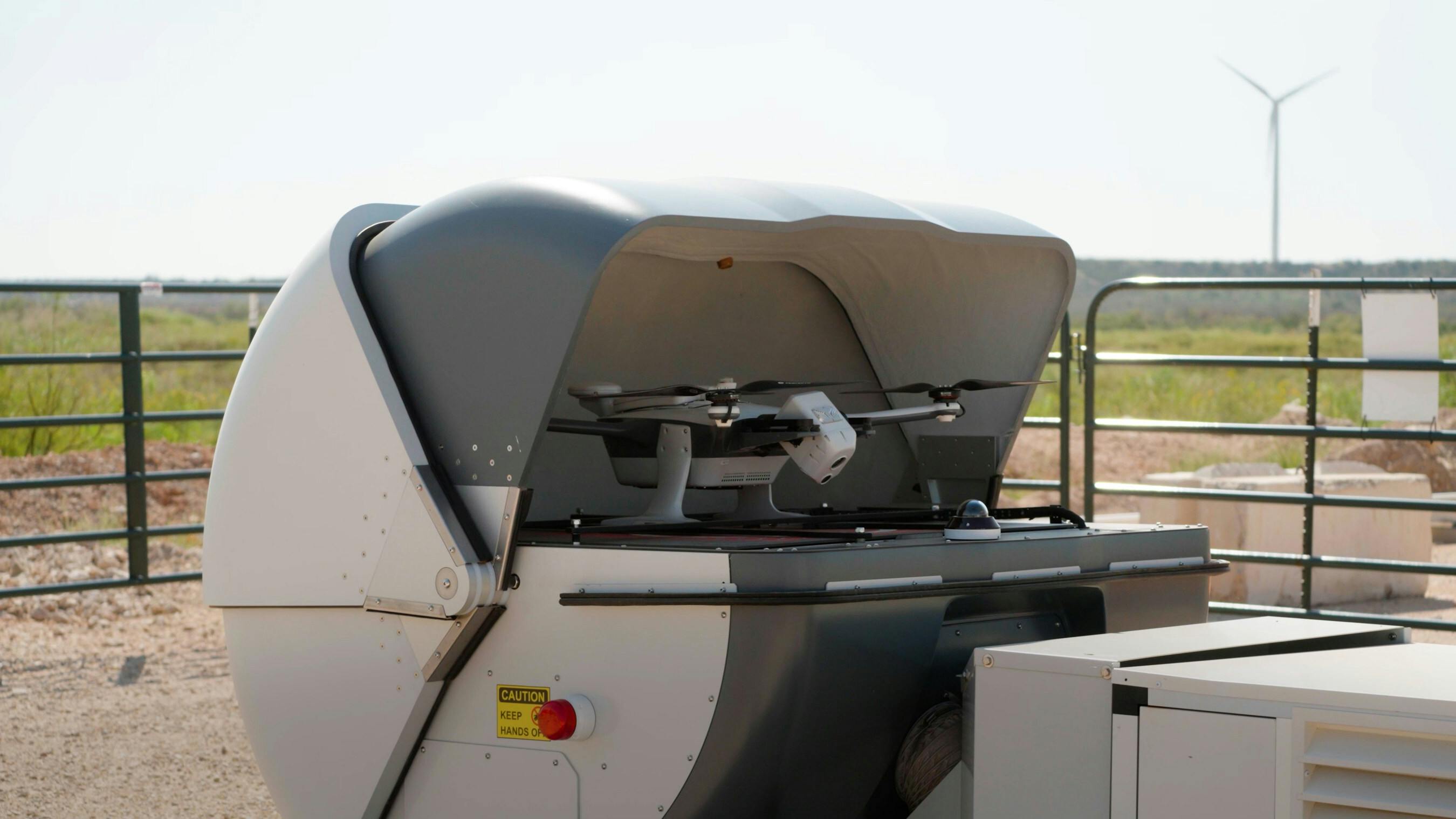 A percepto drone sits in an open container in the field.