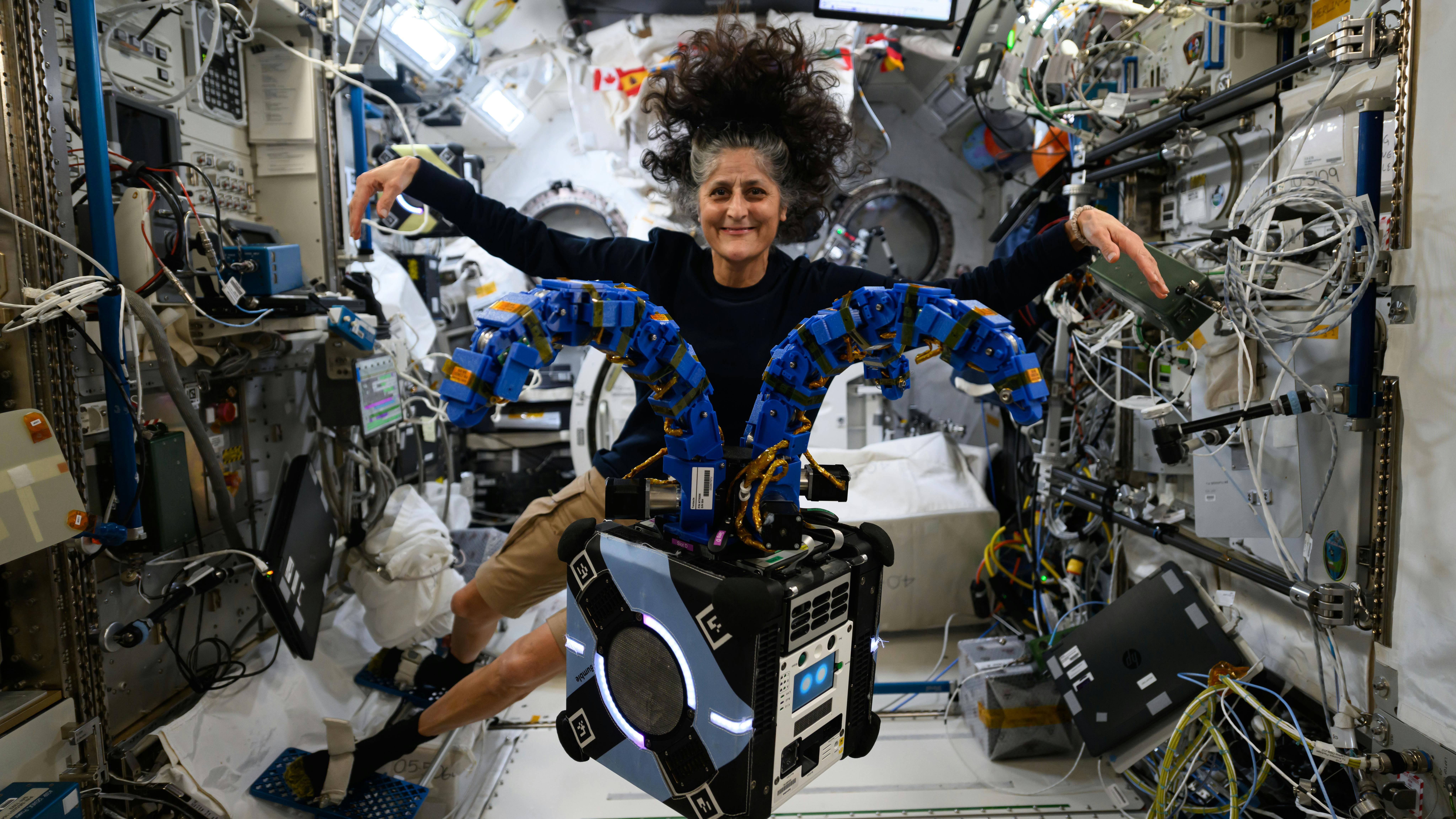 Astronaut Suni Williams floats behind the Astrobee robot onboard the International Space Station