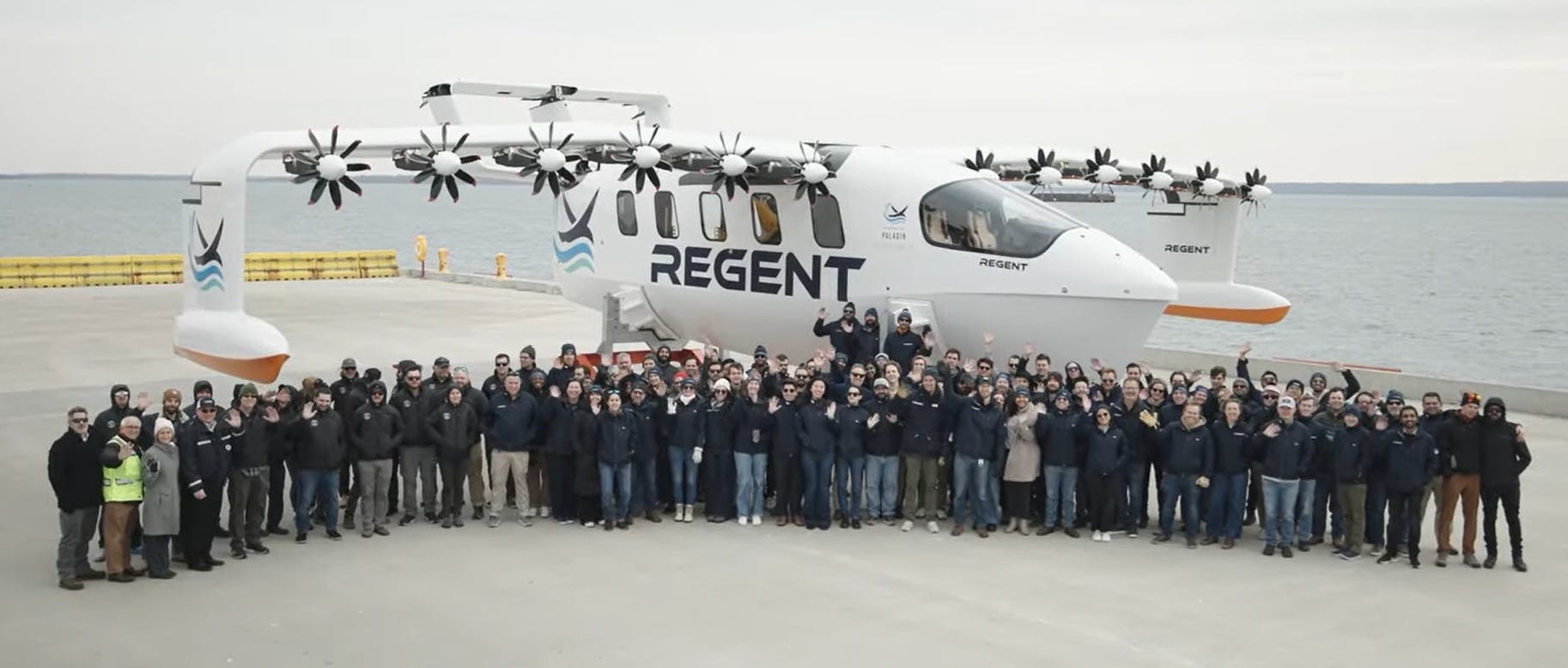 A screencap from Regent's announcement video featuring the vehicle and a group of people posed in front of it
