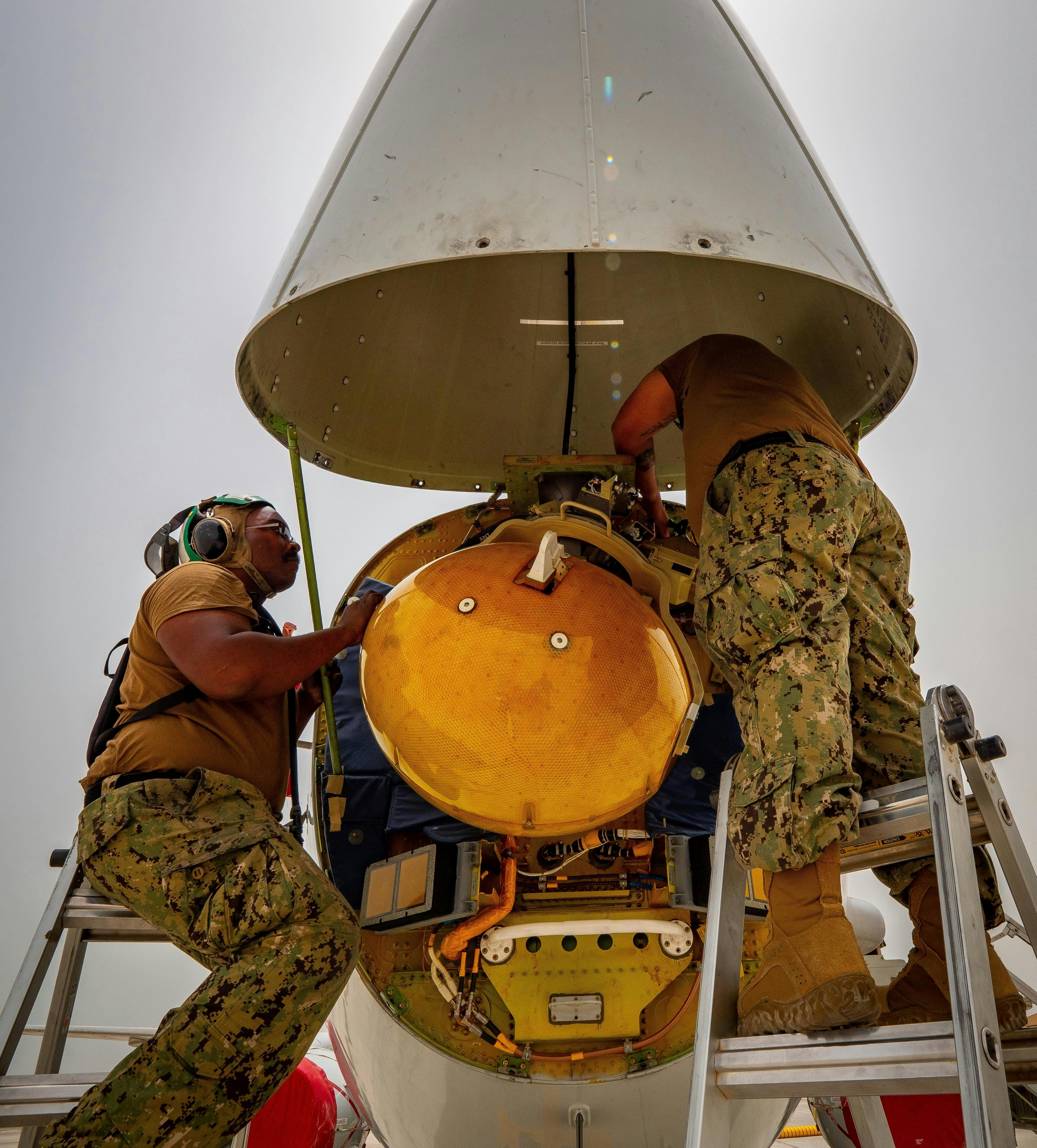 Navy aviation electronics technicians repair the AN/APY-10 radar of a P-8A Poseidon maritime patrol aircraft.