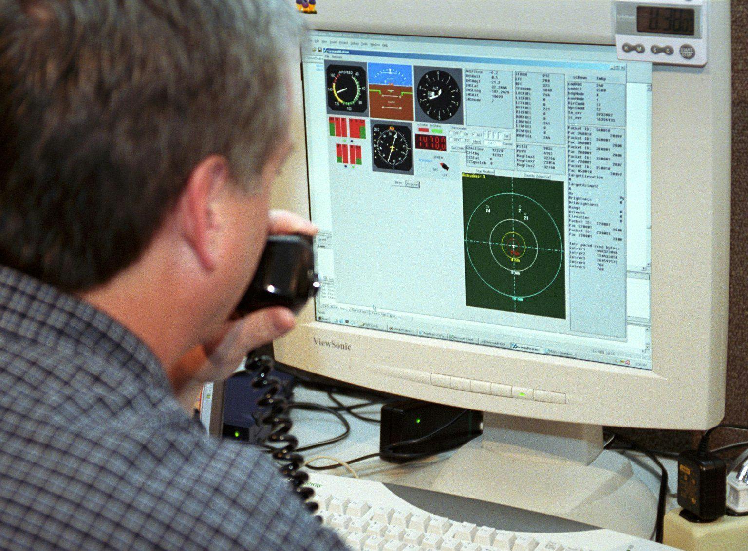 An unmanned vehicle ground controller examines the screen of his ground control station during tests in New Mexico.