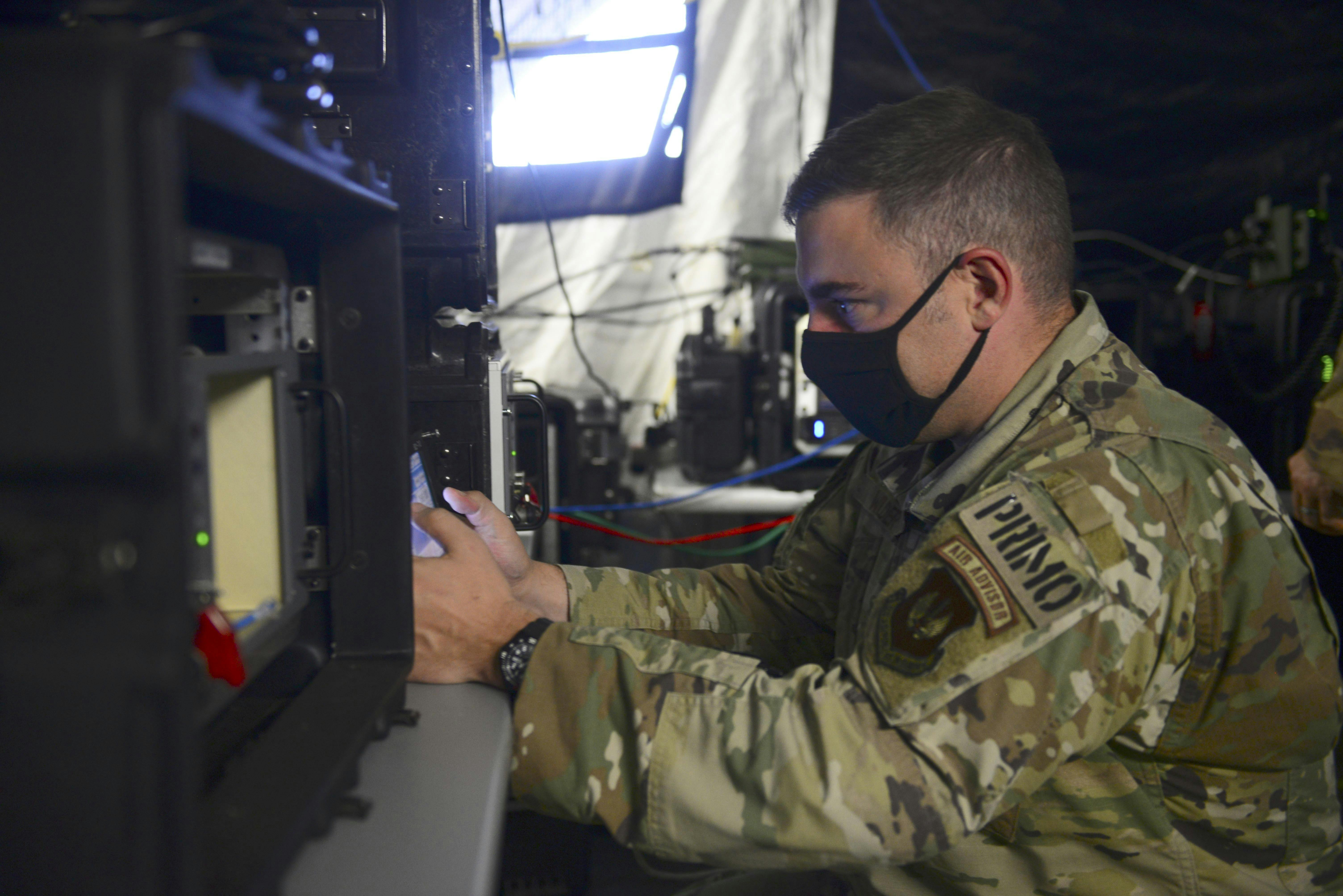 A U.S. Air Force operations superintendent manipulates a UHF radio during exercise Astral Knight 20 at Malbork Air Base, Poland, in 2020. Astral Knight 20 is an integrated air- and missile-defense exercise.