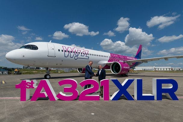 A photo of two business people shaking hands in front of the Wizz Air GTF powered A321xlr