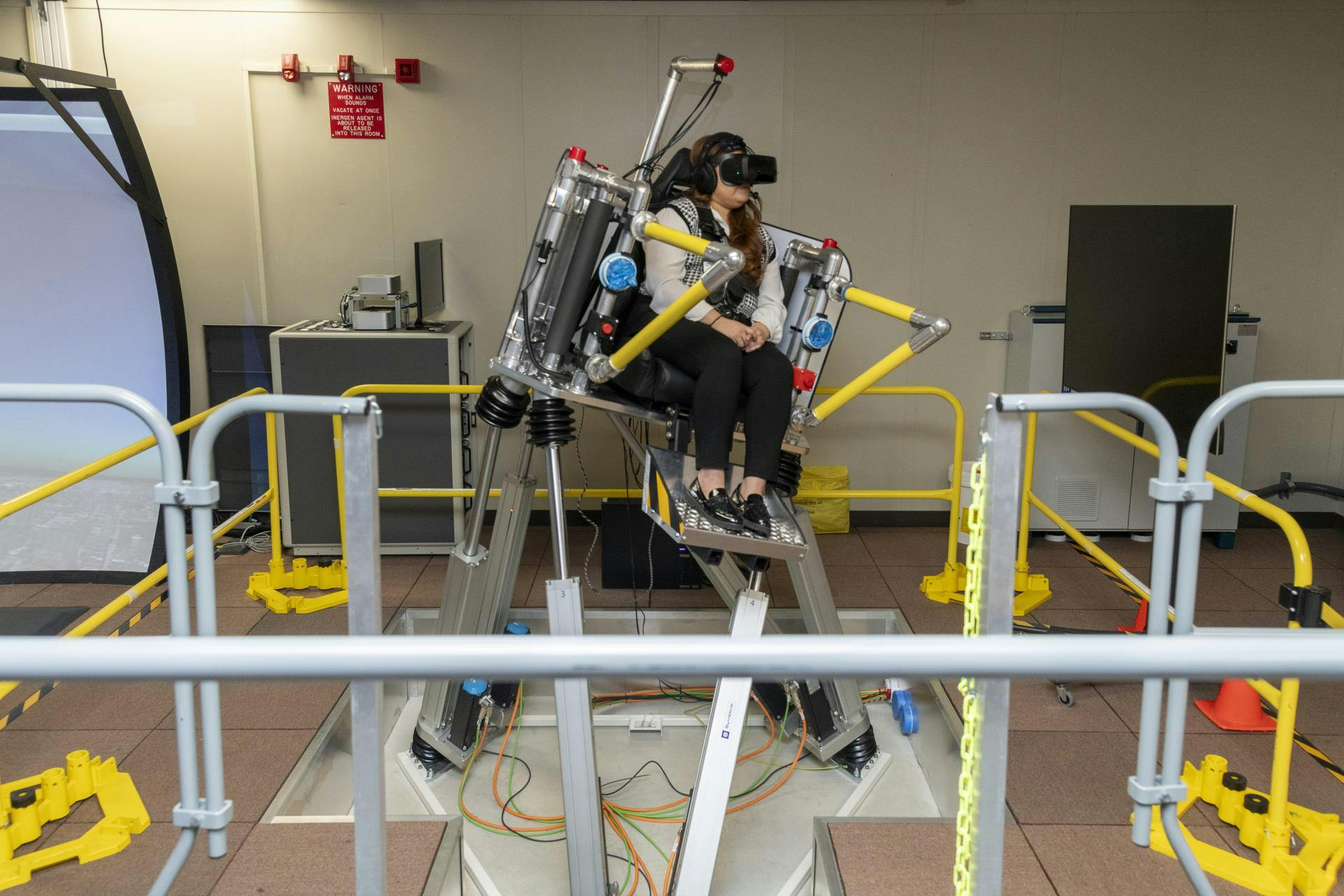 NASA employee Naomi Torres sits inside the air taxi passenger ride quality simulator at NASA&rsquo;s Armstrong Flight Research Center in Edwards, California, as the simulator moves during a study on Oct. 23, 2024. Research continues to better understand how humans may interact with these new types of aircraft. NASA/Steve Freeman photo.