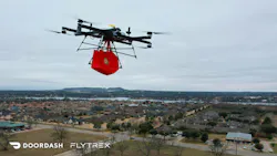 A Flytrex quad copter carrying a bag over a neighborhood A Flytrex quad copter carrying a bag over a neighborhood