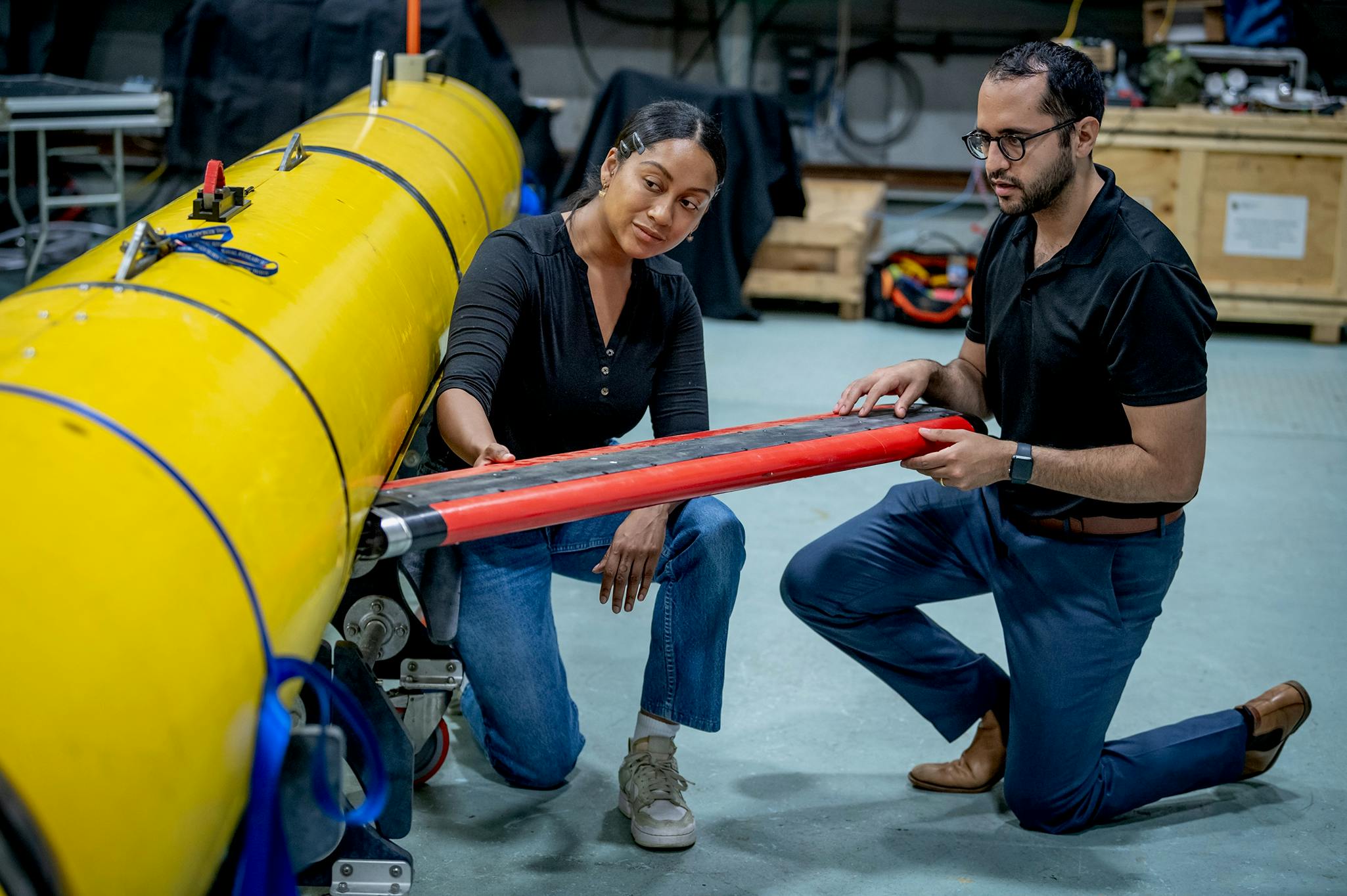 Naval Research Laboratory experts install newly developed payloads on one of the lab's Black Pearl uncrewed underwater vehicles.