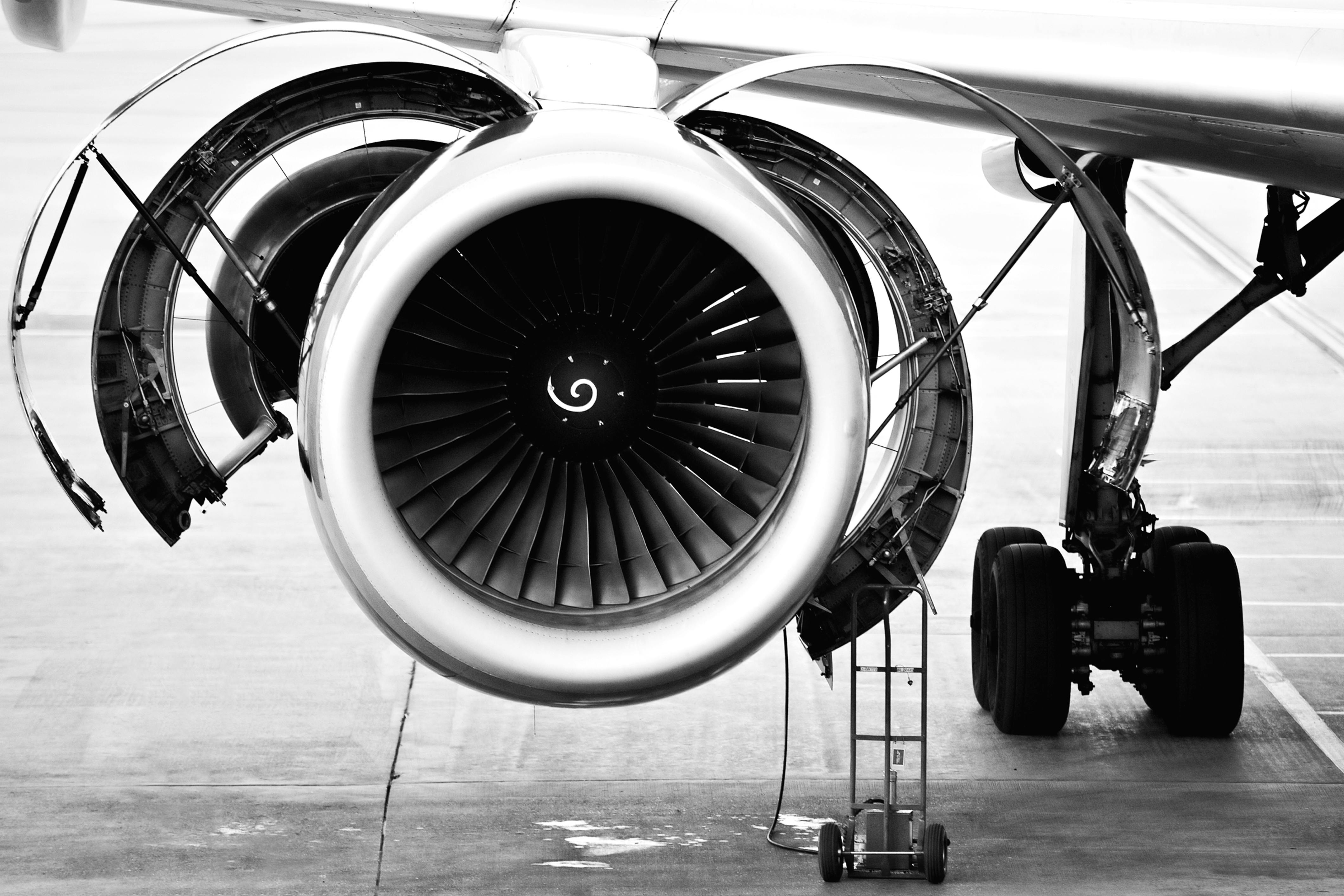 A black and white photo of a jet engine undergoing maintenance