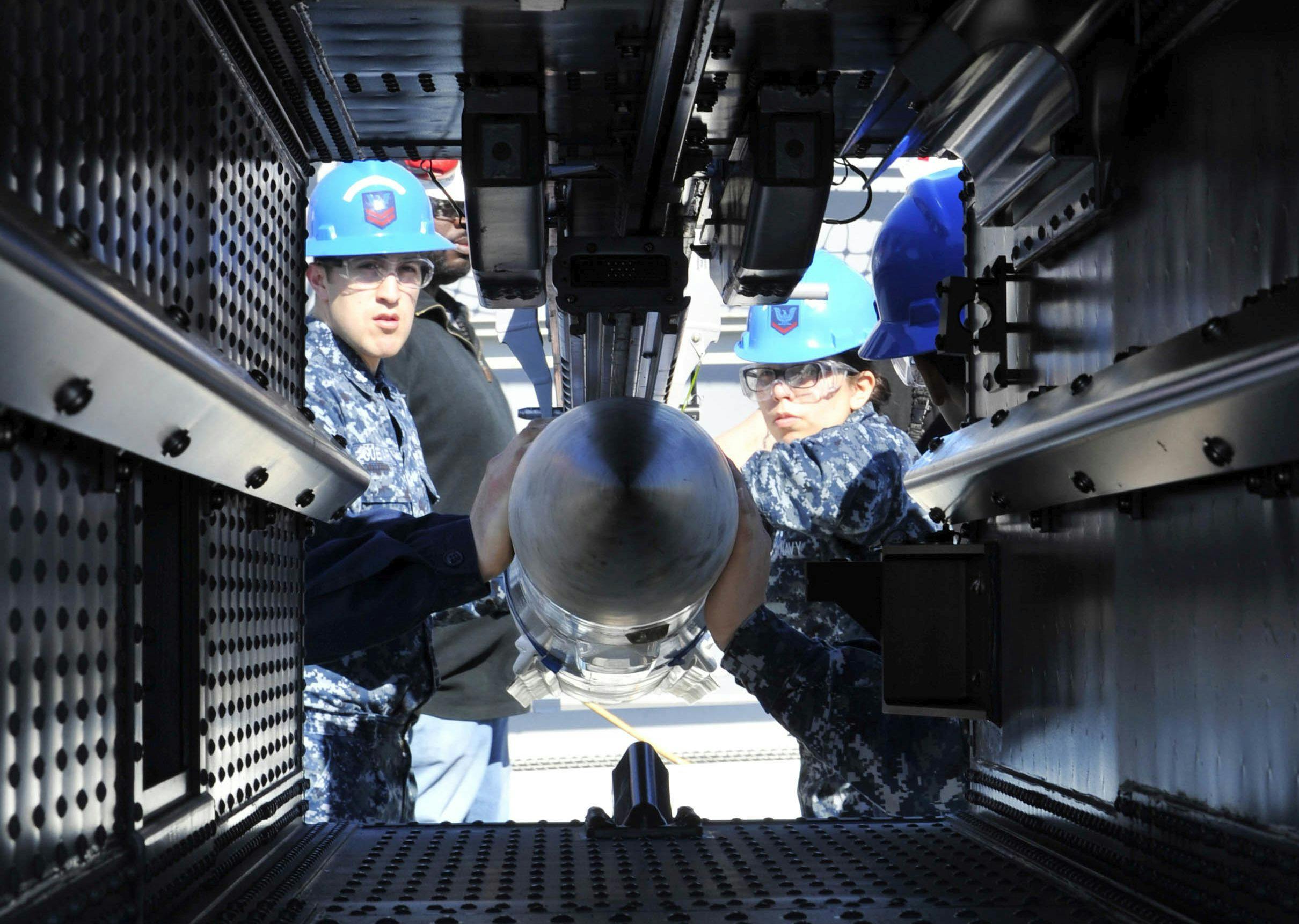 Sailors aboard the aircraft carrier USS Gerald R. Ford (CVN 78) practice loading an inert-dummy RIM-162 Evolved SeaSparrow Missile into a launcher.