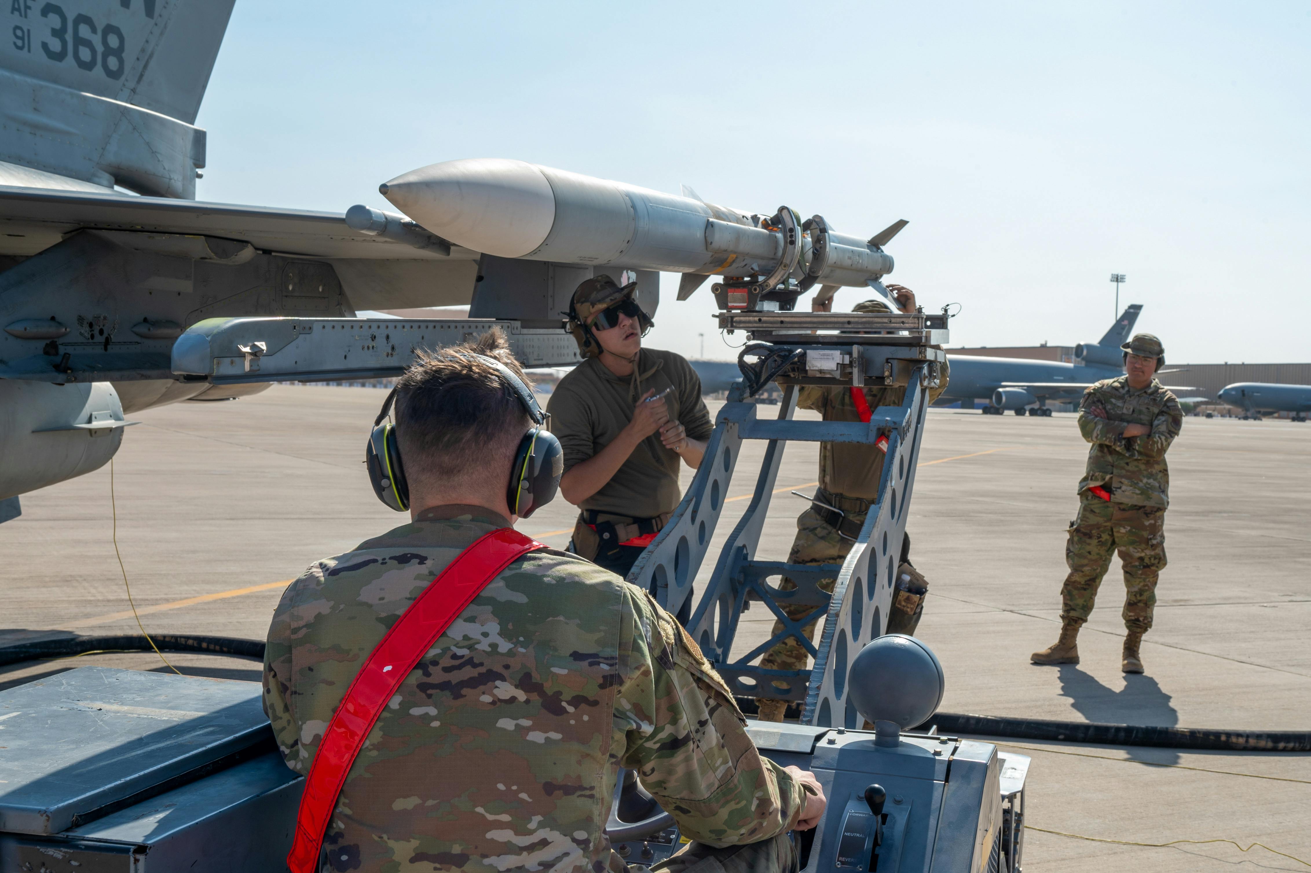 Air Force airmen load an AIM-120 advanced medium-range air-to-air missile (AMRAAM) at Prince Sultan Air Base Kingdom of Saudi Arabia.