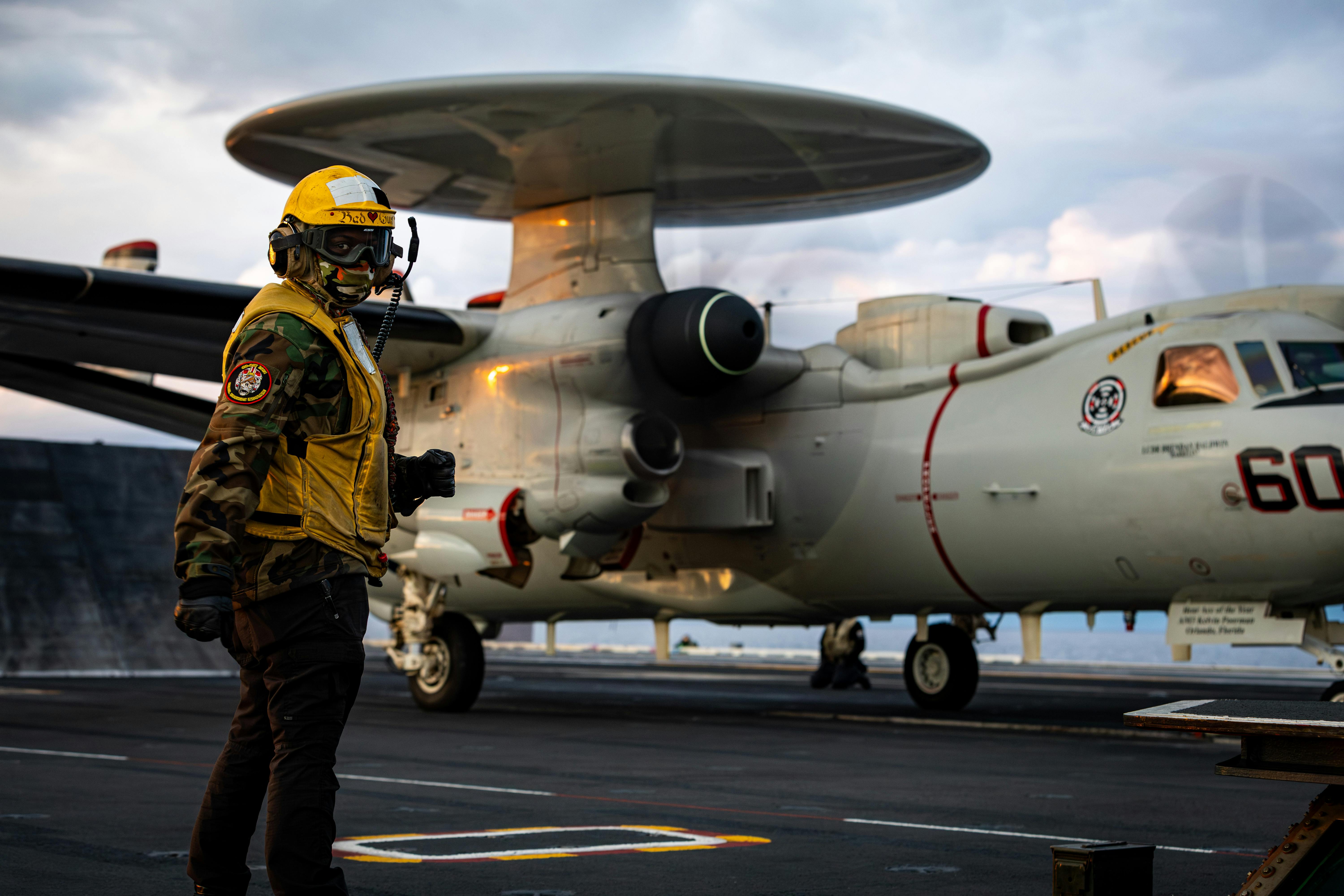 A Navy aviation boatswain&rsquo;s mate signals to an E-2D Hawkeye radar surveillance aircraft earlier this month aboard the aircraft carrier USS Gerald R. Ford.