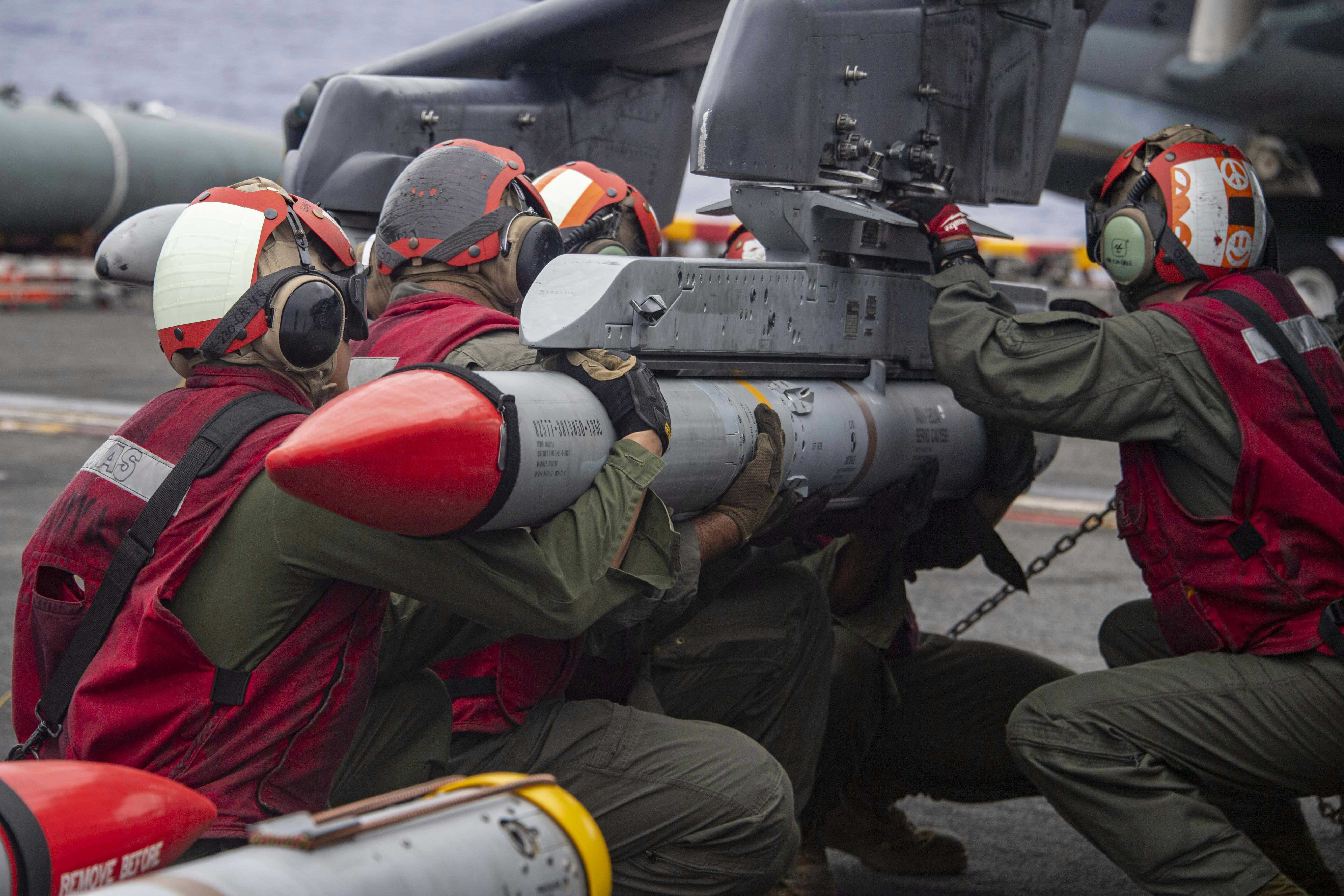 U.S. Marines load an Advanced, Medium-Range, Air-to-Air Missile (AMRAAM), onto an AV-8B Harrier aboard the Wasp-class amphibious assault ship USS Essex (LHD 2) in February 2022.