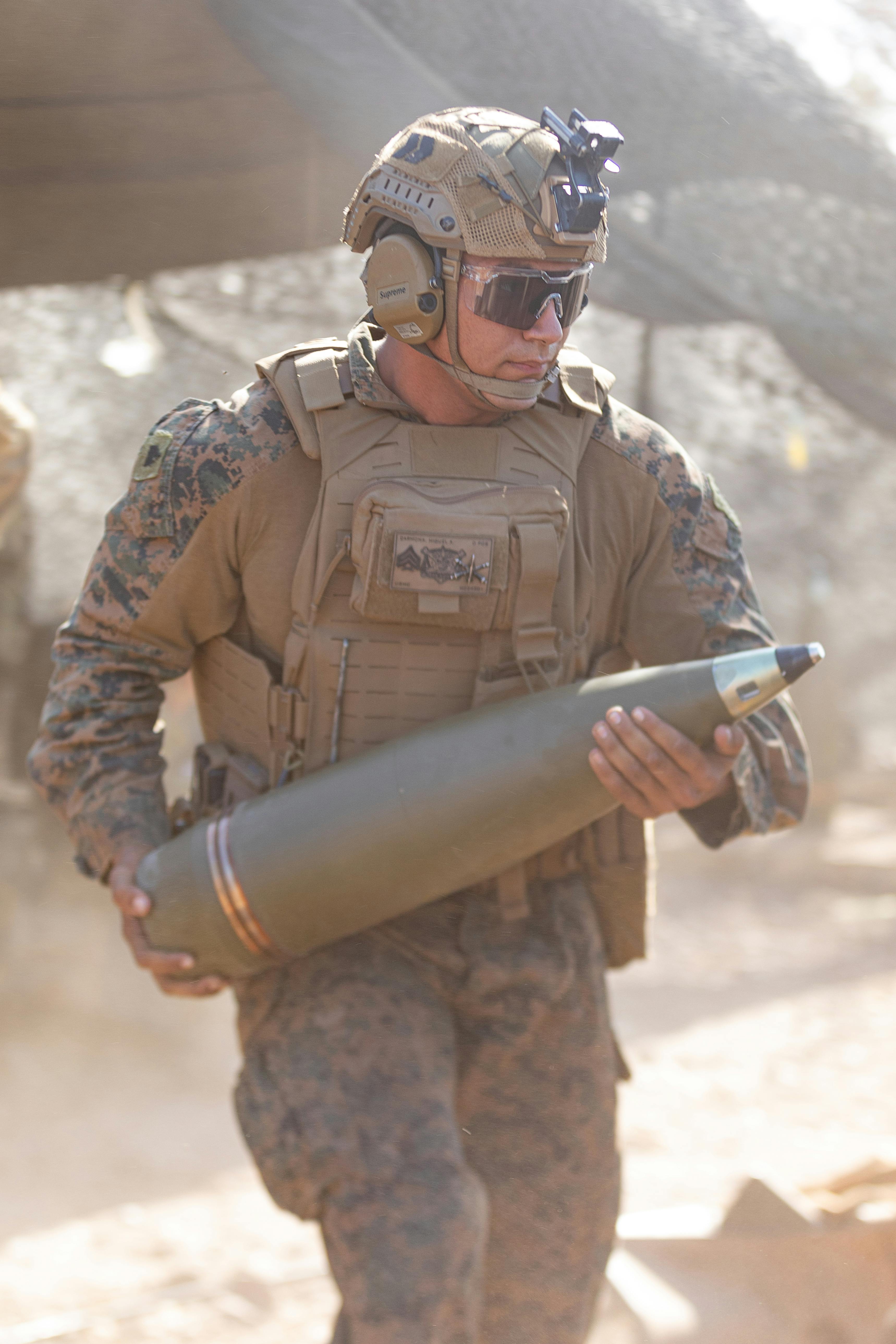 A U.S. Marine Corps howitzer section chief loads a high-explosive projectile into an M777A2 medium towed 155-millimeter howitzer during a 2024 field exercise.