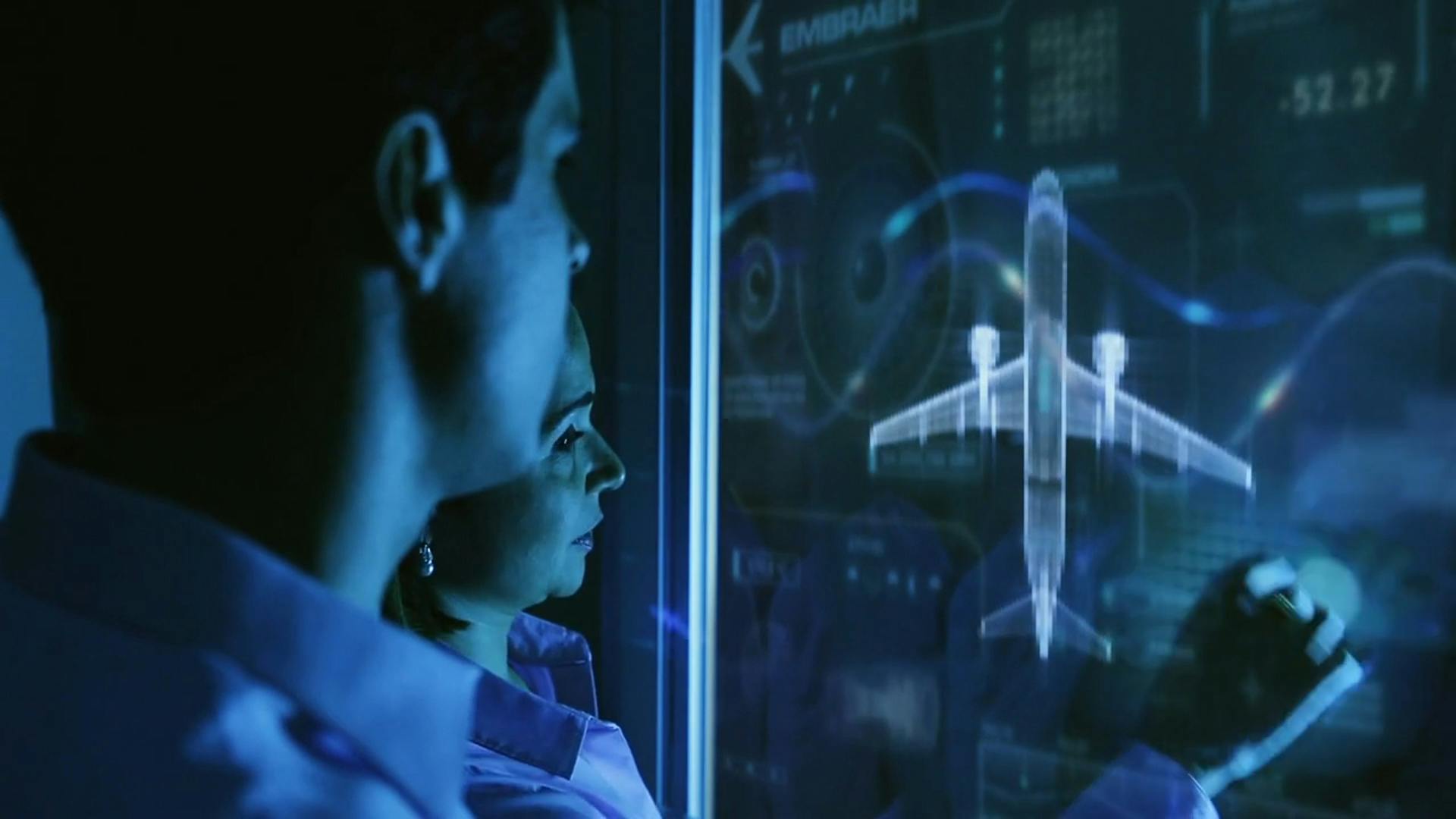 A man and a woman work on a smartboard which displays a commercial airplane.