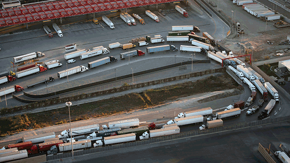 A line of cargo trucks crosses from the Mexican side of the border into the US port of entry at Otay Mesa near San Diego Calif Photo by John MooreGetty Images