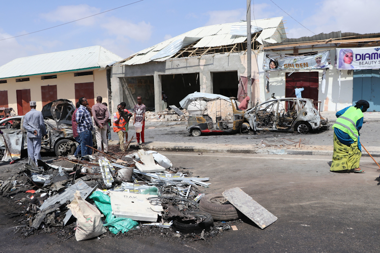 People collect debris at the site where a car bomb exploded near the Somali parliament in Mogadishu, Somalia, on January 8, 2020.