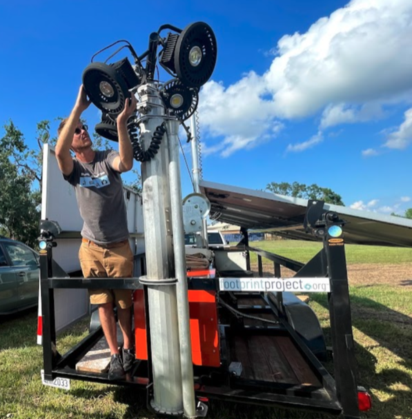 Will Heegaard adjusts security lighting at a volunteer camp in Houma, La. following Hurricane Ida.