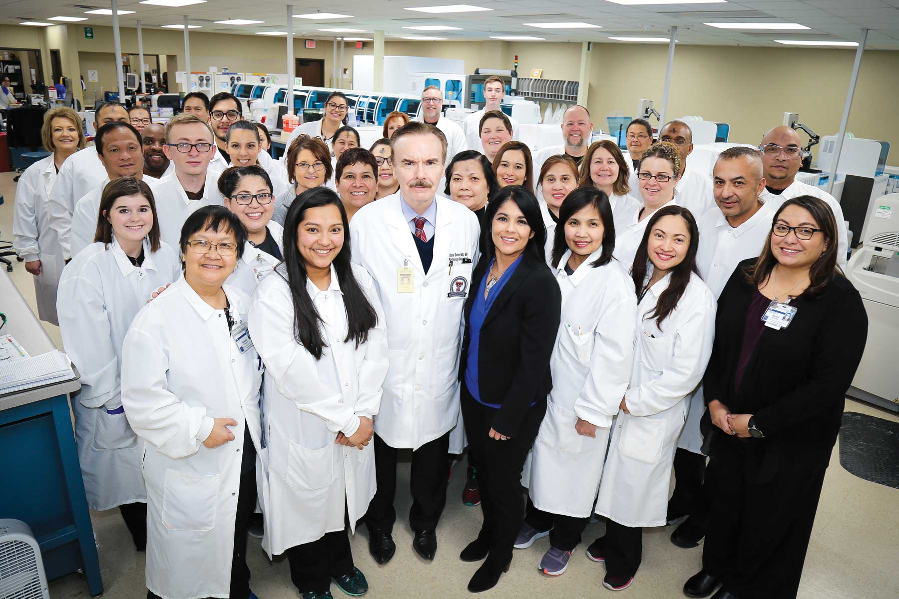 Gary Escoto, MLS(ASCP), JoseLuis Sanchez, MS, MLS(ASCP), and Aubrey Lacirda, MT(AMT) observing Total Lab Automation ribbon cutting presentation