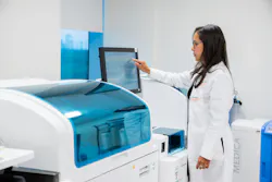 Technologist operating chemistry analyzer. Technologist operating chemistry analyzer.