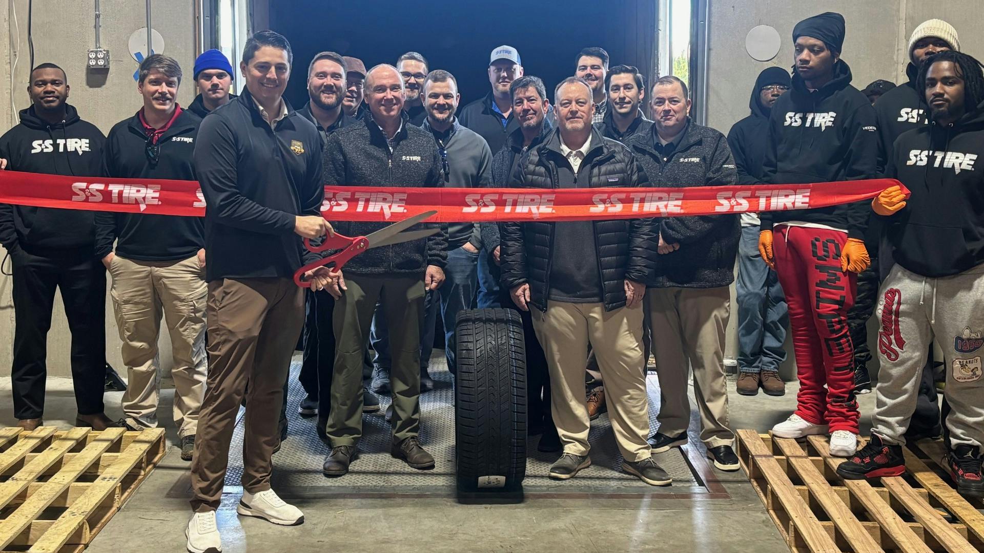 Brock Swentzel, president of S&S Tire's wholesale division, marks the first load of tires at the company's new distribution center in Acworth, Ga.. with a ribbon cutting.