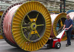 Man moving industrial sized spool with machine Man moving industrial sized spool with machine