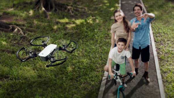 A promotional photo of a family taking a selfie with the DJI Spark drone