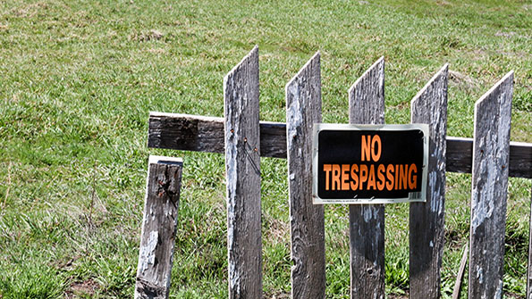 No trespassing sign on wooden fence
