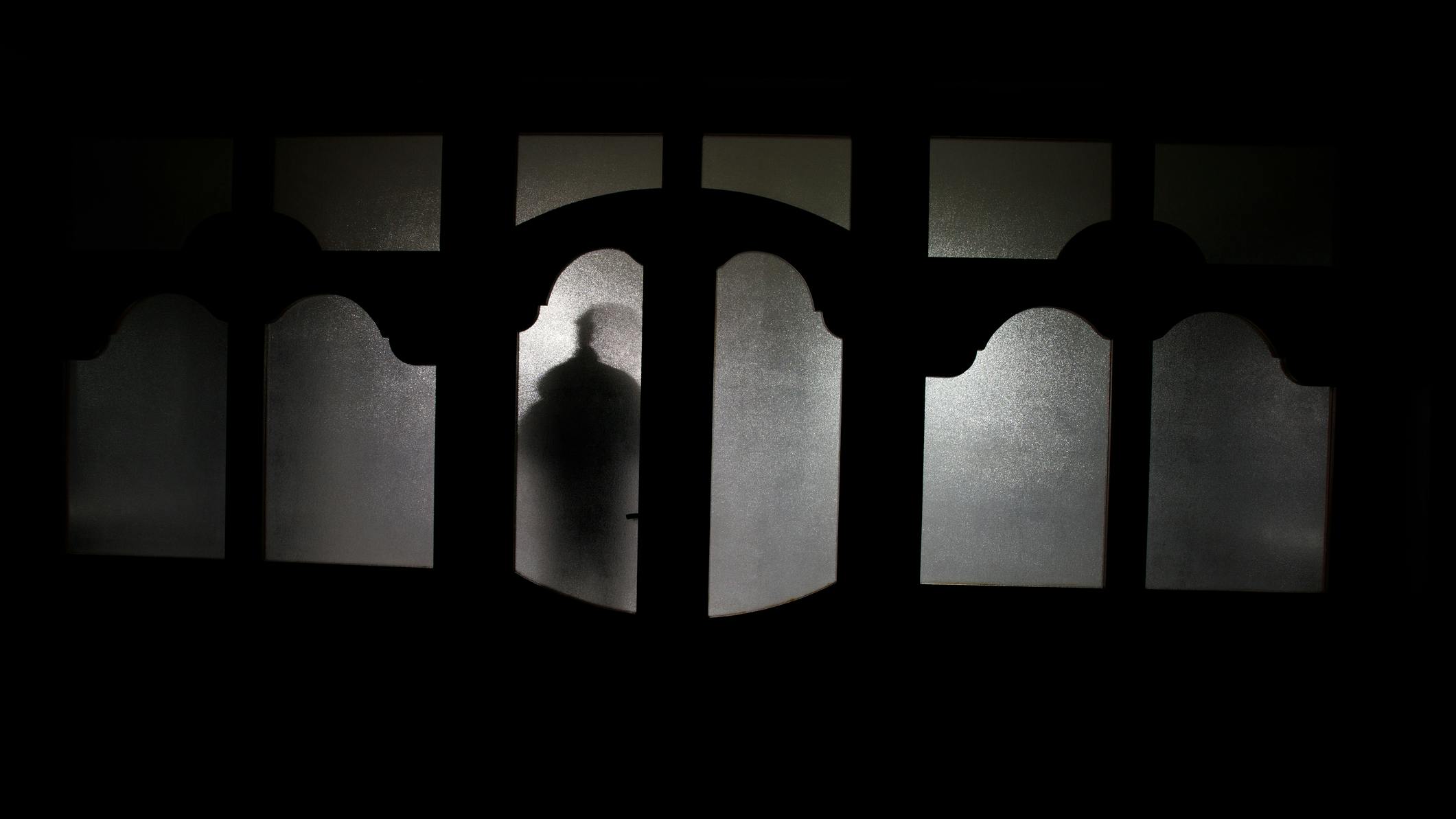 Silhouette Of An Unknown Shadow Figure On A Door