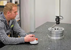 Ray Harris inspecting a scaled-down race car wheel for wind tunnel testing. Ray Harris inspecting a scaled-down race car wheel for wind tunnel testing.