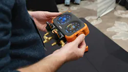 NAVAC Flex-X Manifold Gauge being held in users hands at tradeshow NAVAC Flex-X Manifold Gauge being held in users hands at tradeshow