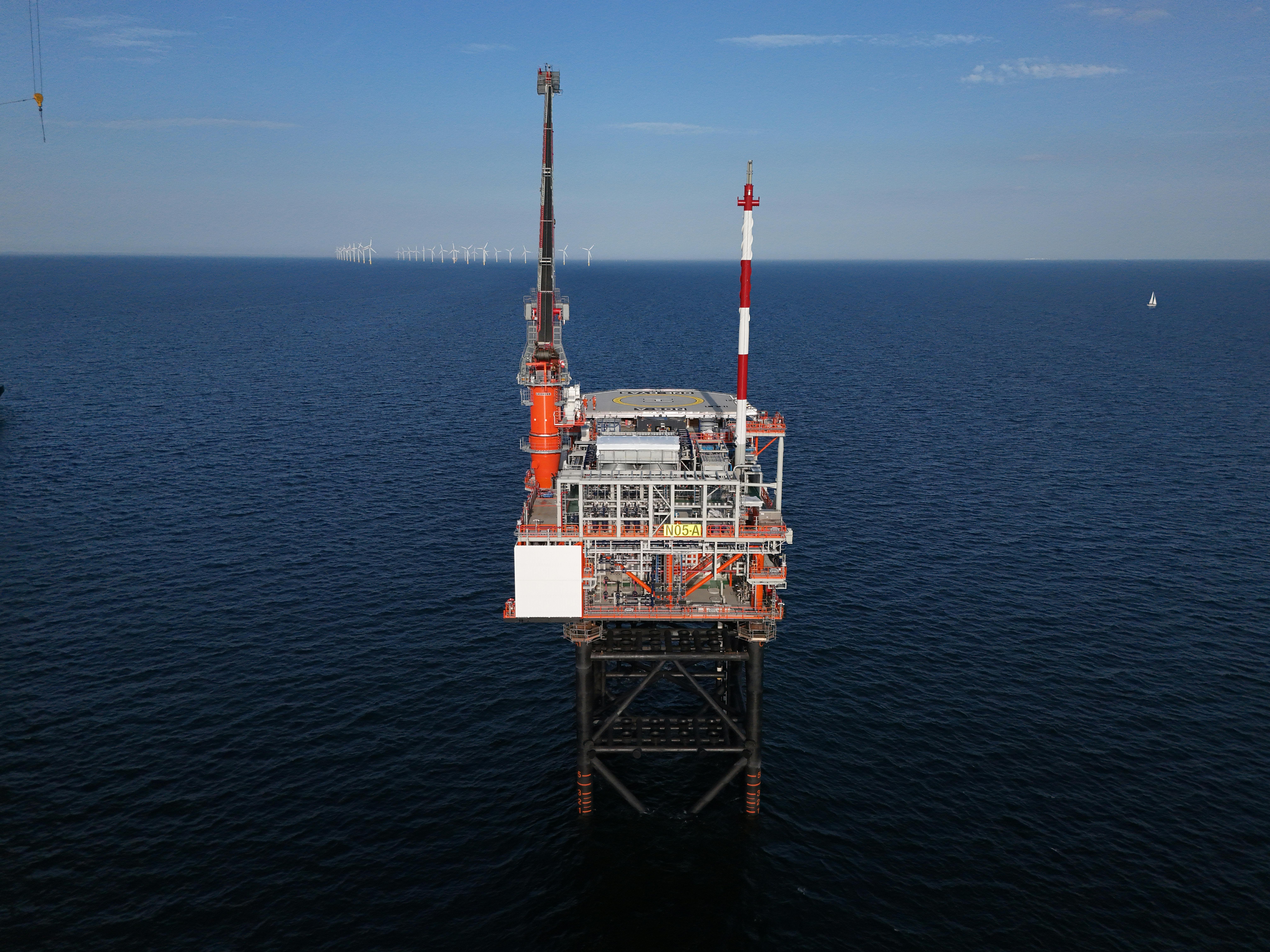 Production platform N05-A in the Dutch North Sea with view of windfarm in the background.