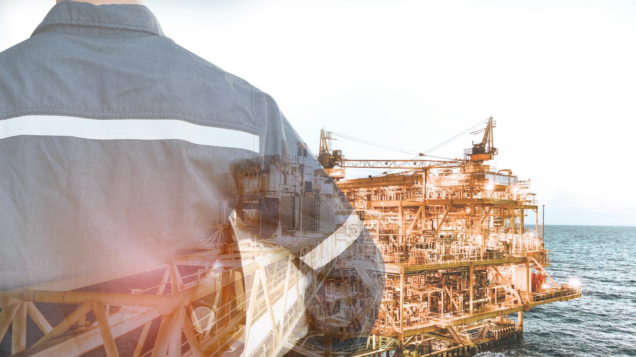 Double exposure of engineer man holding safety hat, offshore oil and gas platform background
