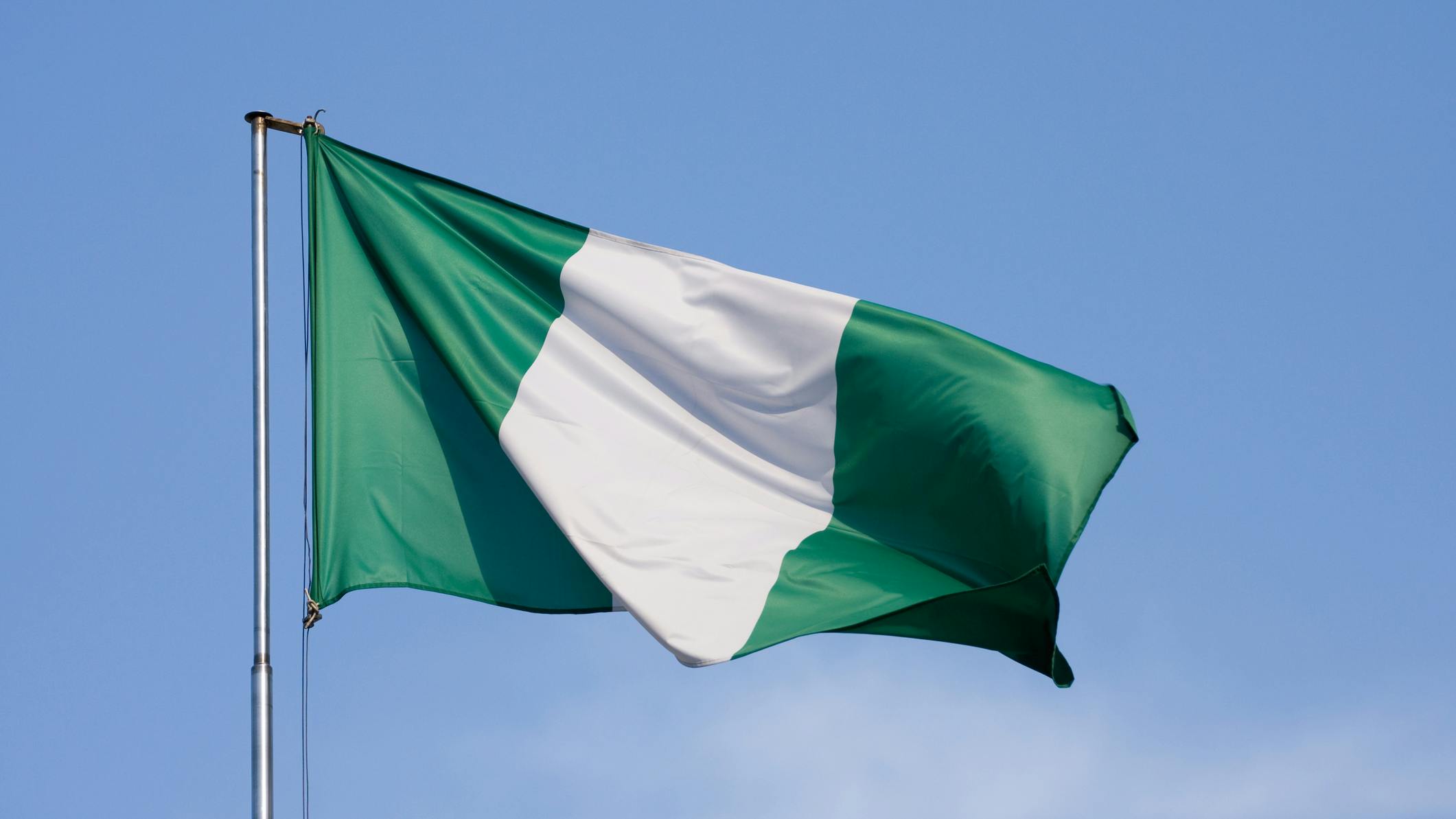 Flag of Nigeria on a background blue sky