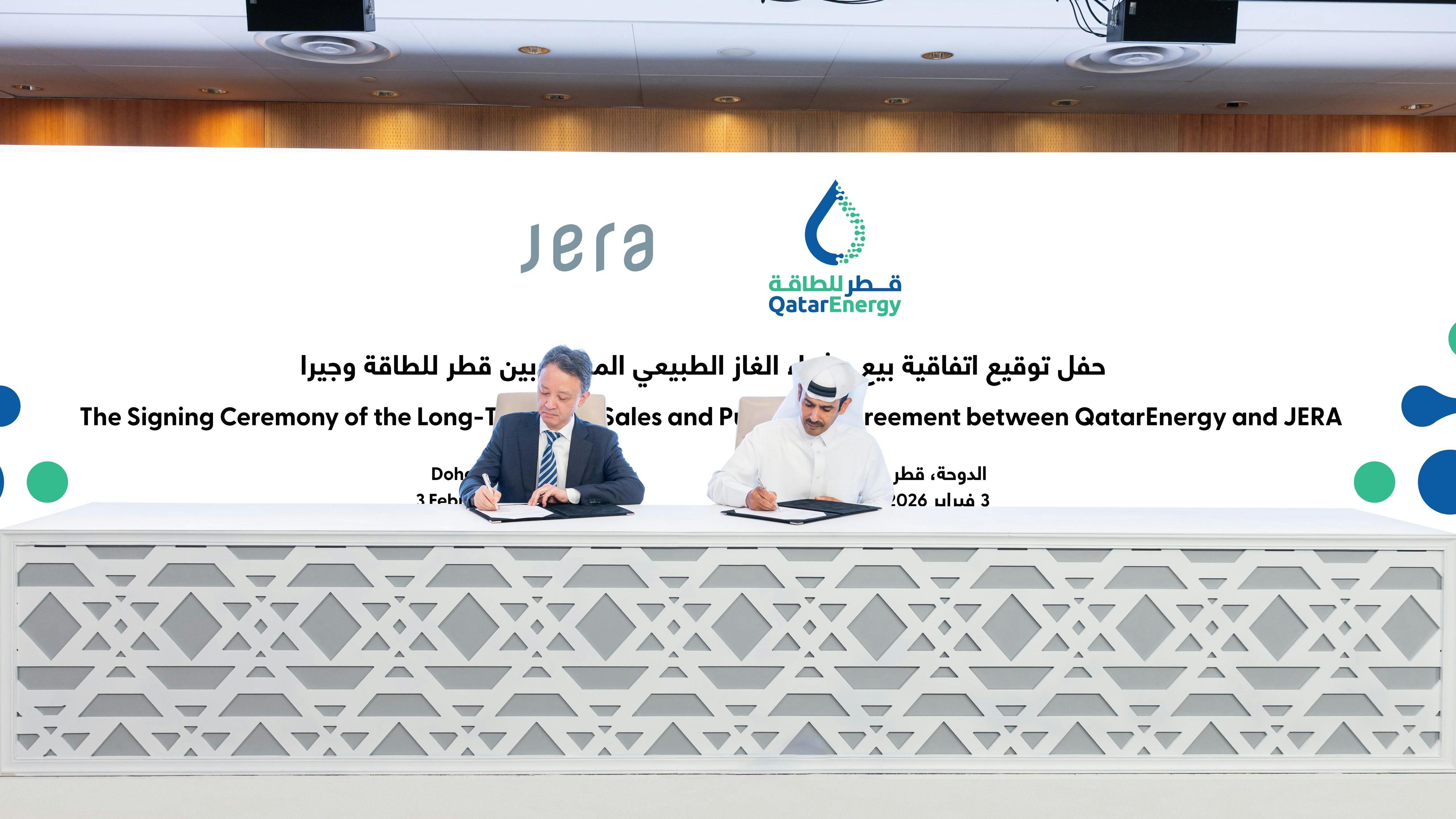 two men signing contracts at a table at a conference