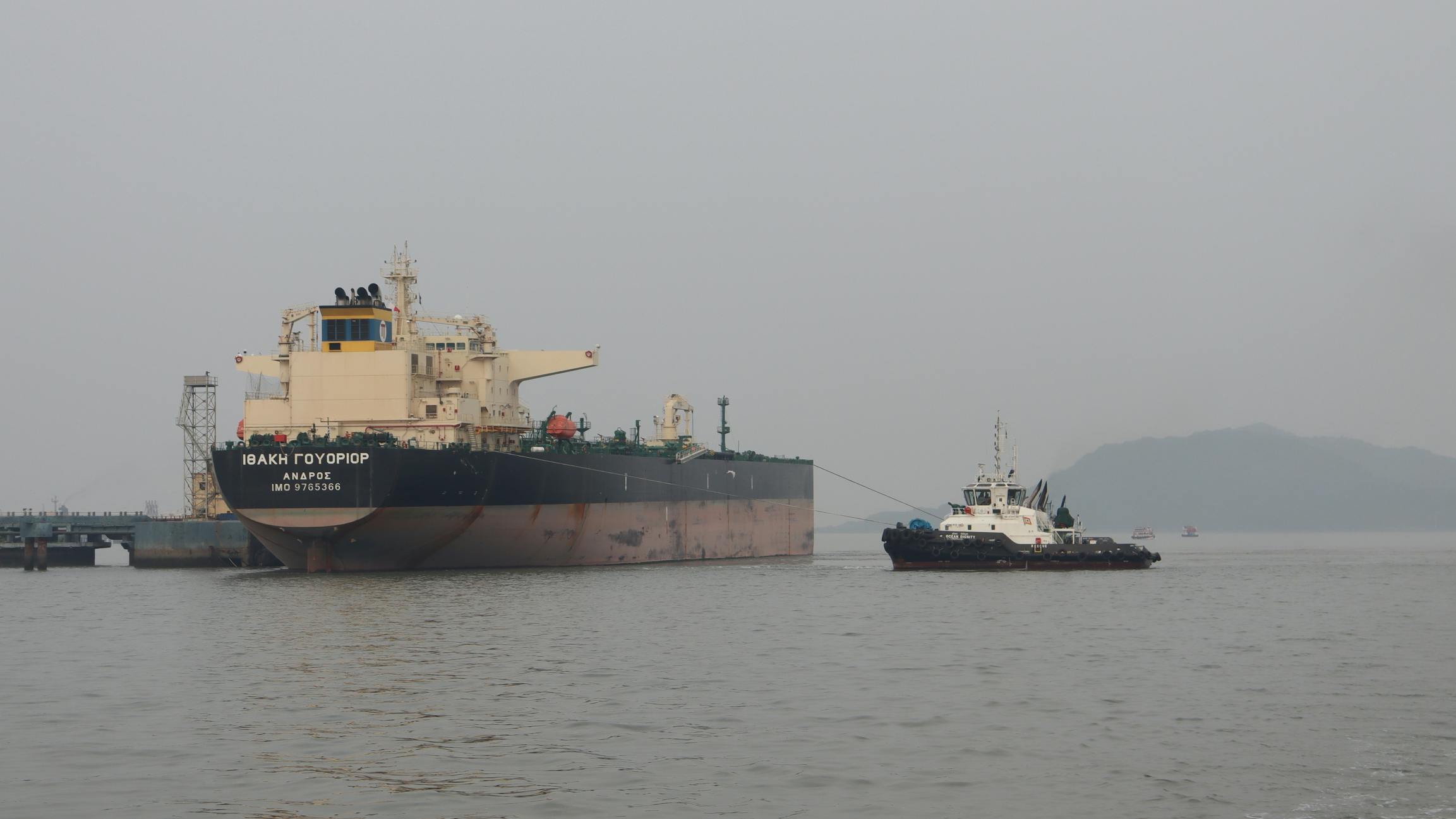 Russian oil tanker at dockyard with tugboat