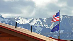 American and Alaskan flag fly atop a building in the mountains of Denali American and Alaskan flag fly atop a building in the mountains of Denali