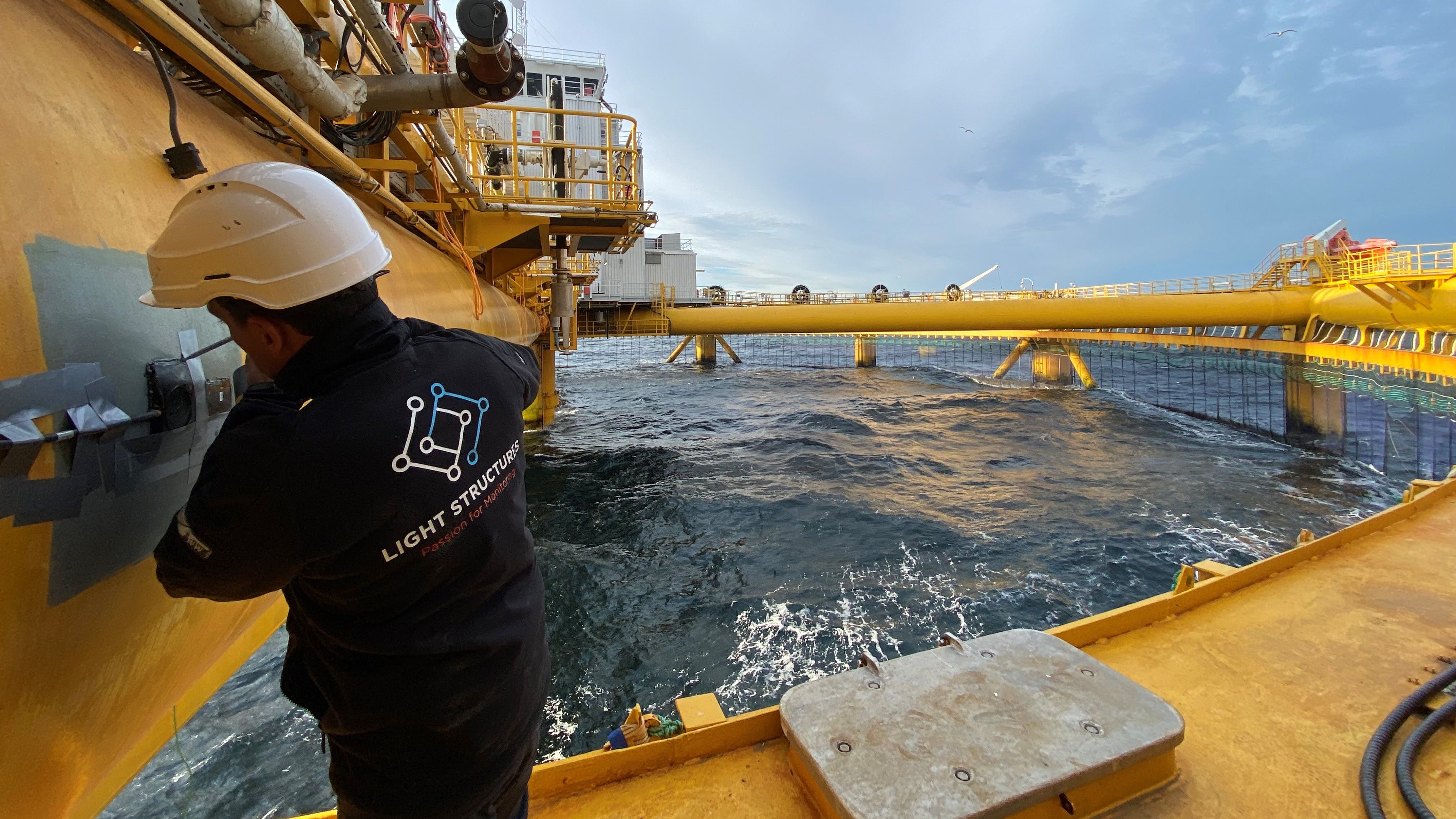 Besides FPSOs, Light Structures says SENSFIB structural hull monitoring is used on a variety of vessels and platforms, from coast guard cutters to container ships and LNG tankers. The photo shows a SENSFIB sensor being installed on Ocean Farm 1, an exposed fish farm facility testbed installed offshore Norway.