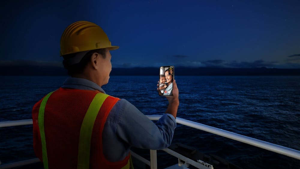 An AI-generated image depicts an offshore crew member video chatting with family.