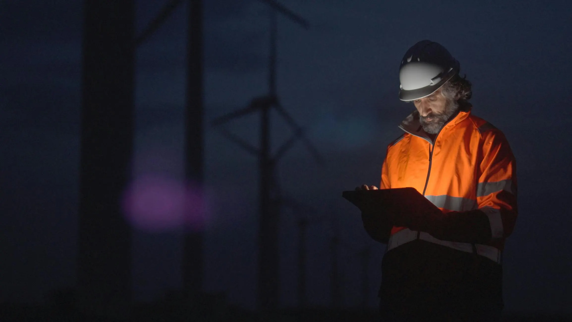 person on device among wind turbines