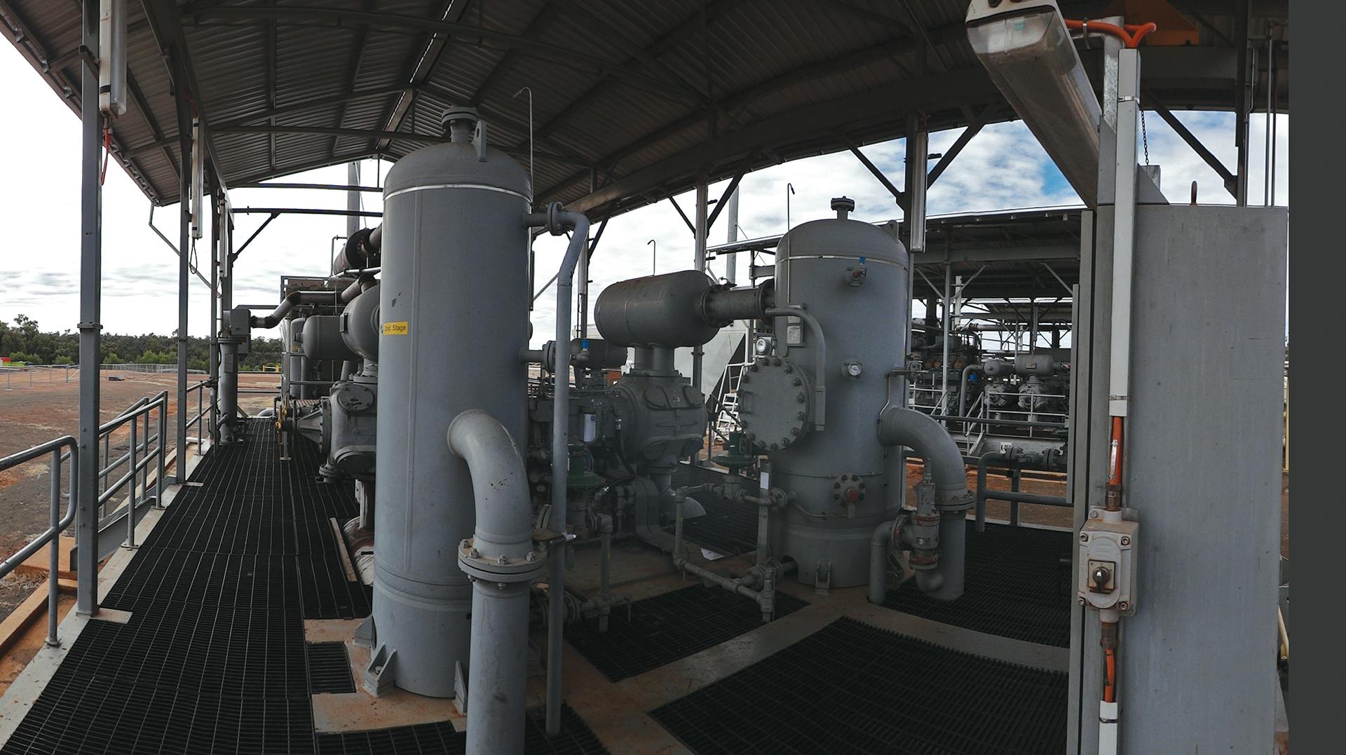 An example of a reciprocating compressor package with pulsation vessels (horizontal pulsation bottles at top and bottom of cylinders), auxiliaries and piping.