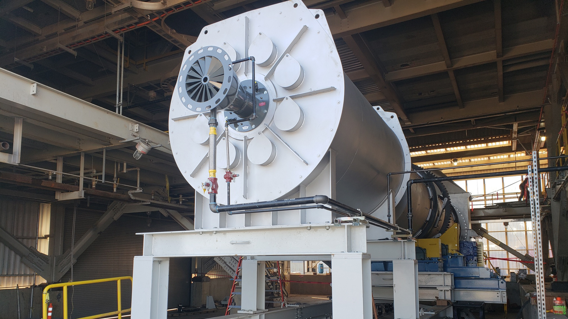 A rotary dryer with a combustion chamber on rails allows the combustion chamber to be easily moved away for maintenance and cleaning of the rotary dryer.