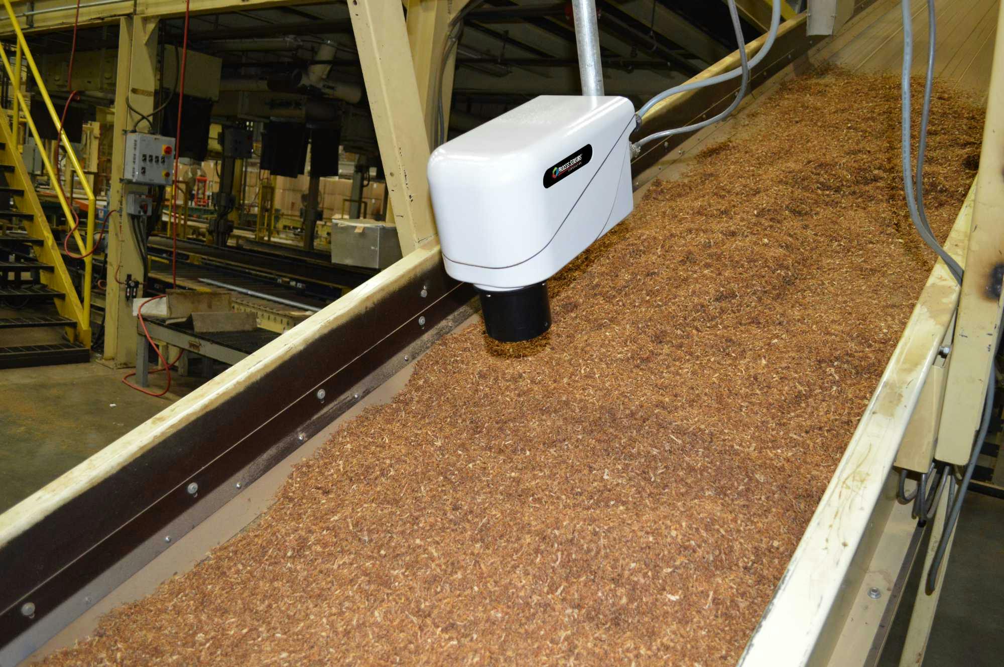 Online NIR moisture analyzer scanning moisture content of a tobacco processing plant.