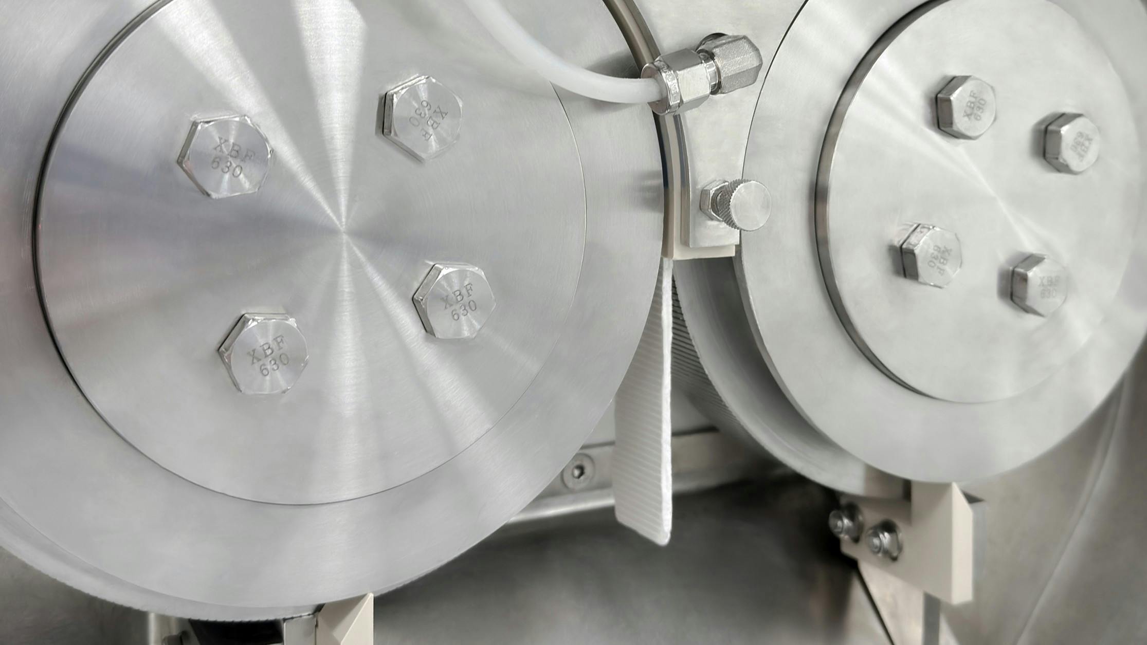 Roll compactor discharging a ribbon of compressed material.