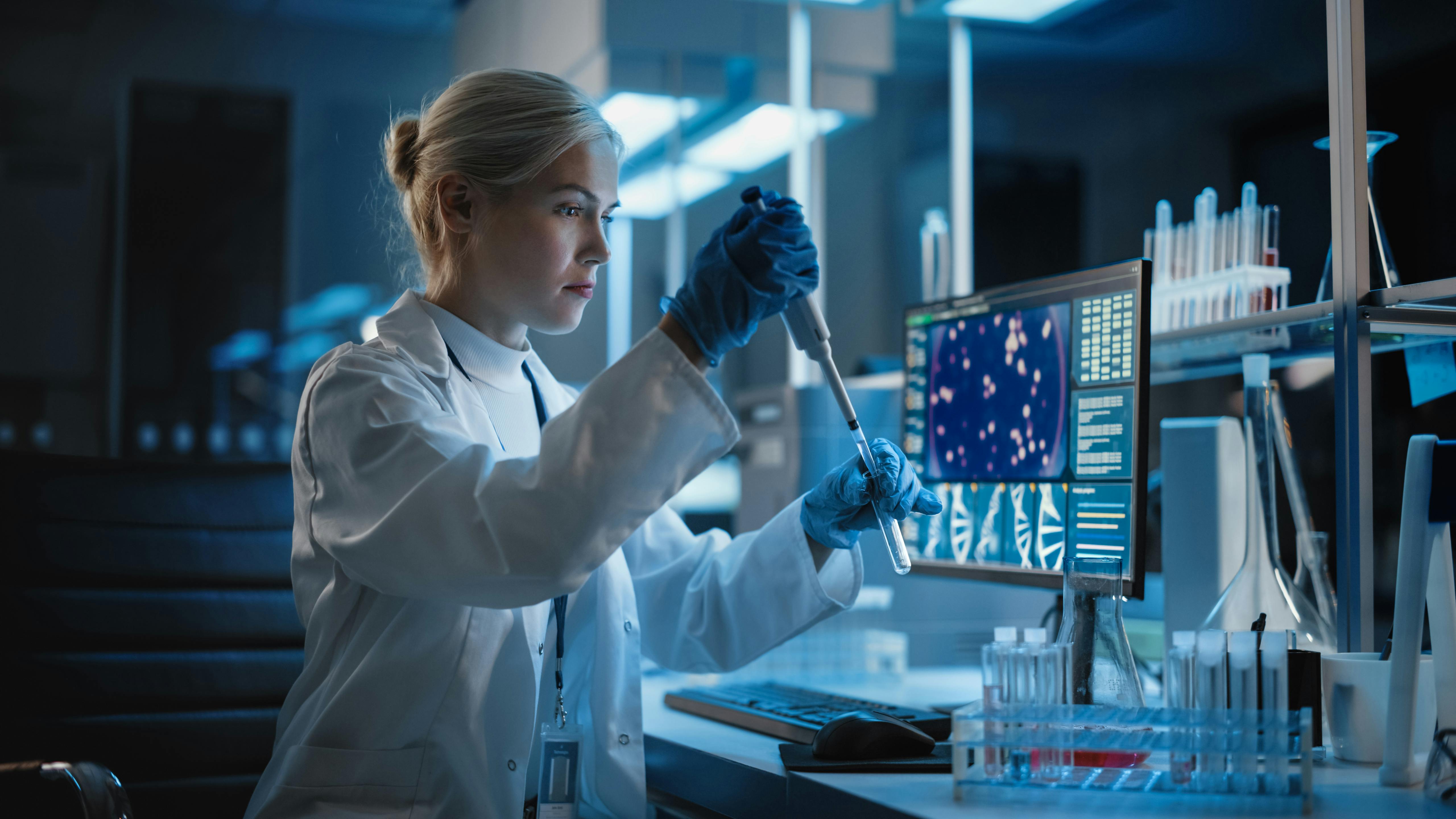 Female scientist working with samples, using micro pipette to analyze in a lab