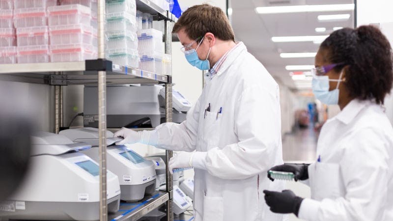 Workers in labcoats in Moderna facility