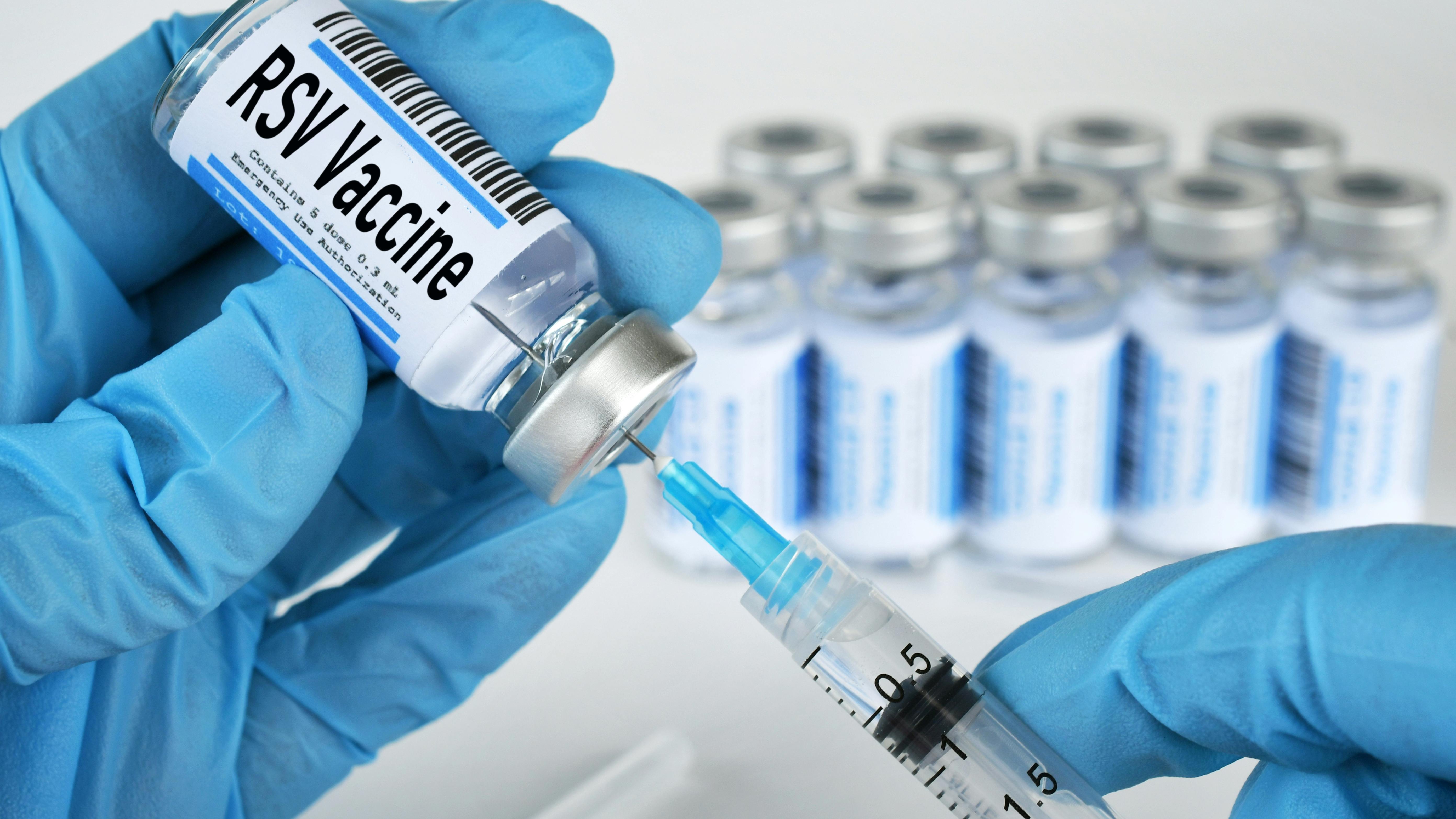 Medical personnel filling a syringe needle with RSV vaccine from vial