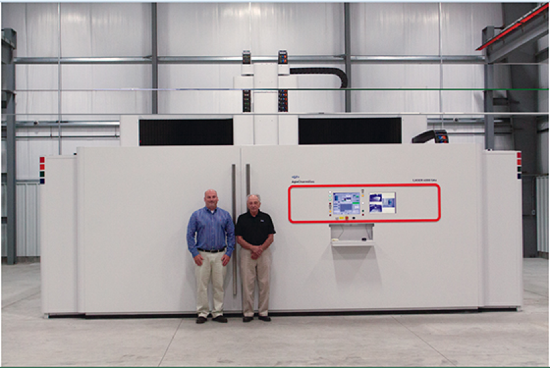 Custom Etch officials VP Don Melonio, left, and President C. Henry Melonio pose in front of an AgieCharmilles laser-etching machine.