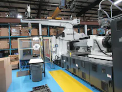 A recently installed 1,300-ton Milacron servo-hydraulic injection molding machine with a HyRobotics robot cell and a 15-ton bridge crane system overhead A recently installed 1,300-ton Milacron servo-hydraulic injection molding machine with a HyRobotics robot cell and a 15-ton bridge crane system overhead
